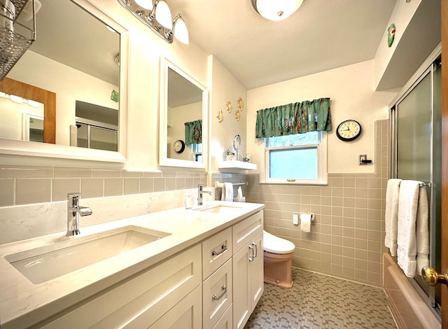 9186 Arnold St, Redford, MI 48239 - full bathroom with tile walls, toilet, wainscoting, double vanity, and enclosed tub / shower combo