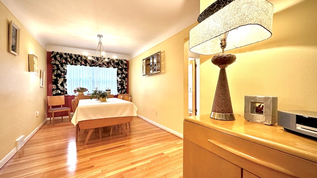 9186 Arnold St, Redford, MI 48239 - dining room featuring a chandelier, light wood-style floors, and baseboards