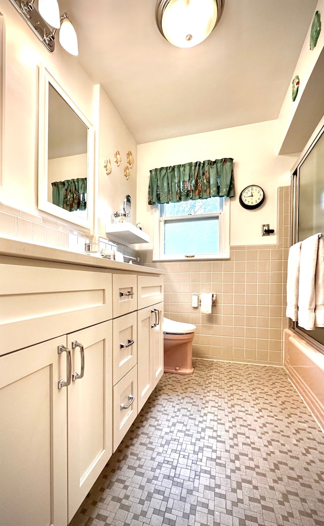 9186 Arnold St, Redford, MI 48239 - full bath with tile walls, toilet, vanity, a wainscoted wall, and enclosed tub / shower combo