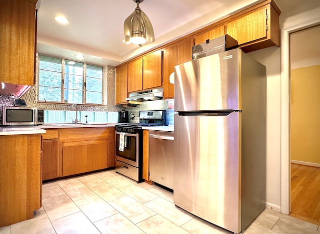 9186 Arnold St, Redford, MI 48239 - kitchen featuring stainless steel appliances, under cabinet range hood, a sink, light countertops, and backsplash