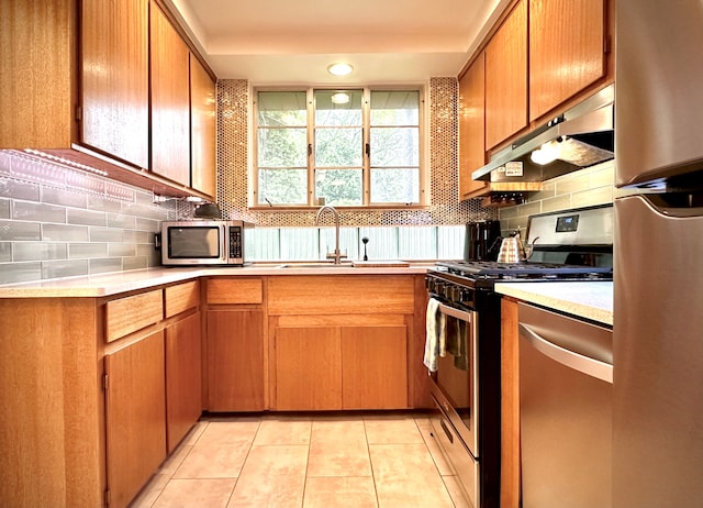 9186 Arnold St, Redford, MI 48239 - kitchen with appliances with stainless steel finishes, under cabinet range hood, a sink, light countertops, and tasteful backsplash