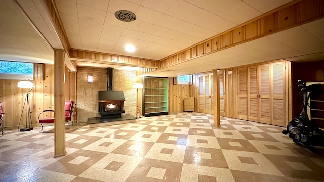 9186 Arnold St, Redford, MI 48239 - finished basement with tile patterned floors, wood walls, and a wood stove