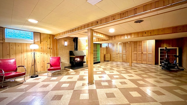 9186 Arnold St, Redford, MI 48239 - basement featuring wood walls, tile patterned floors, and a wood stove