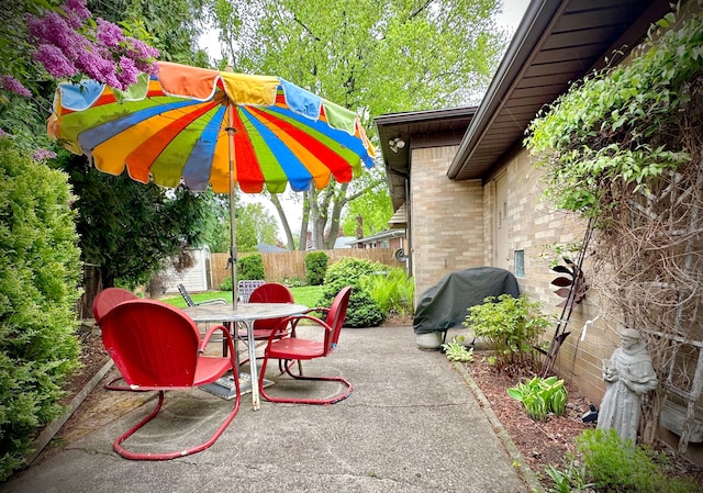 9186 Arnold St, Redford, MI 48239 - view of patio featuring outdoor dining space, grilling area, fence, a storage unit, and an outdoor structure