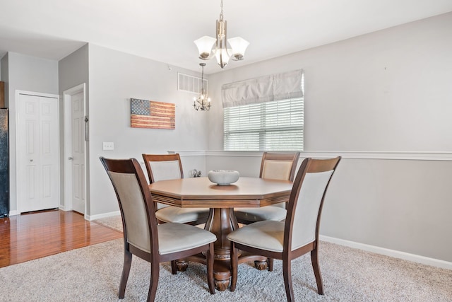 dining space with baseboards, an inviting chandelier, visible vents, and carpet