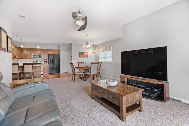 living room featuring a notable chandelier, baseboards, and visible vents