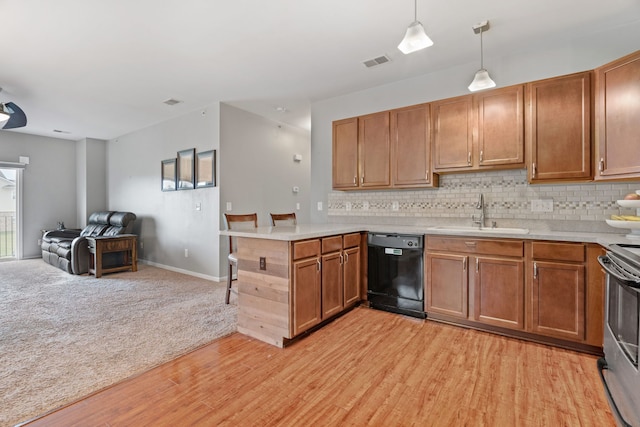 kitchen with a peninsula, a sink, black dishwasher, open floor plan, and visible vents