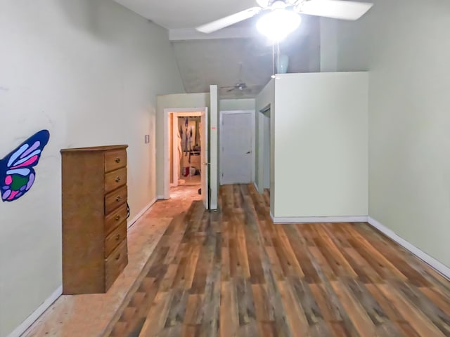 unfurnished bedroom featuring baseboards, ceiling fan, wood finished floors, and lofted ceiling