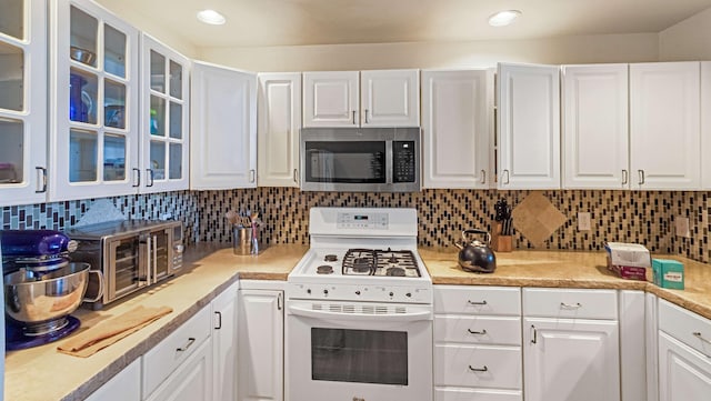 kitchen featuring light countertops, a toaster, white cabinets, stainless steel microwave, and white range with gas cooktop