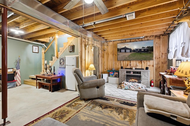 living area featuring visible vents, a glass covered fireplace, and stairway