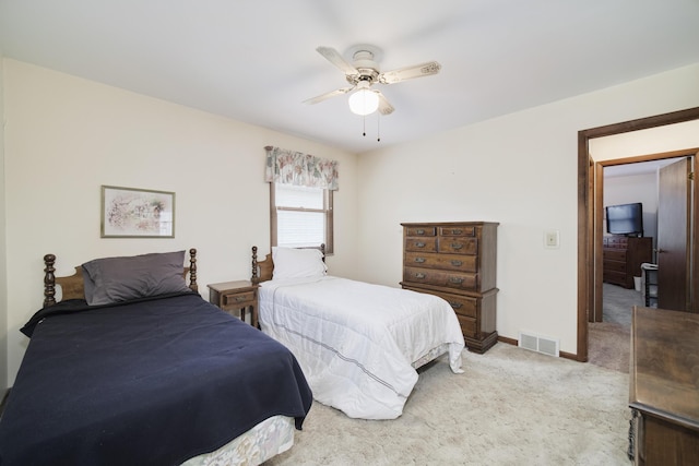 carpeted bedroom with a ceiling fan and visible vents