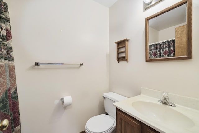 full bath featuring toilet, a shower with shower curtain, and vanity
