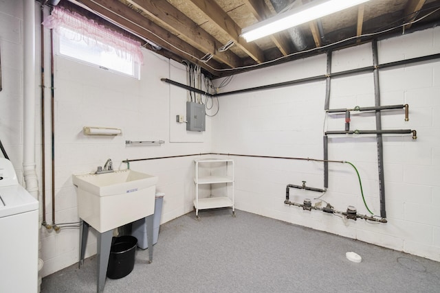 below grade area featuring concrete block wall, electric panel, and washer / clothes dryer