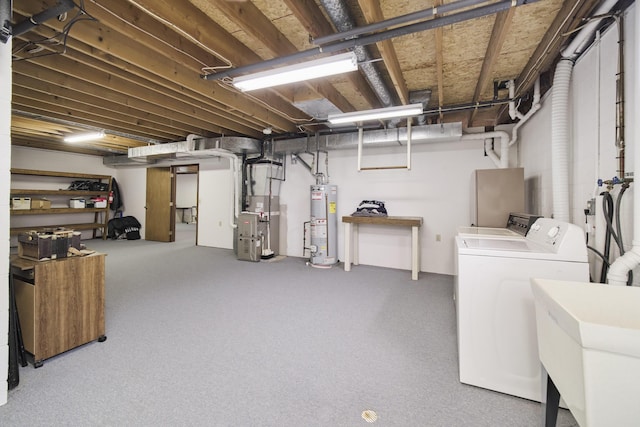 unfinished below grade area featuring heating unit, washer and clothes dryer, gas water heater, a sink, and carpet