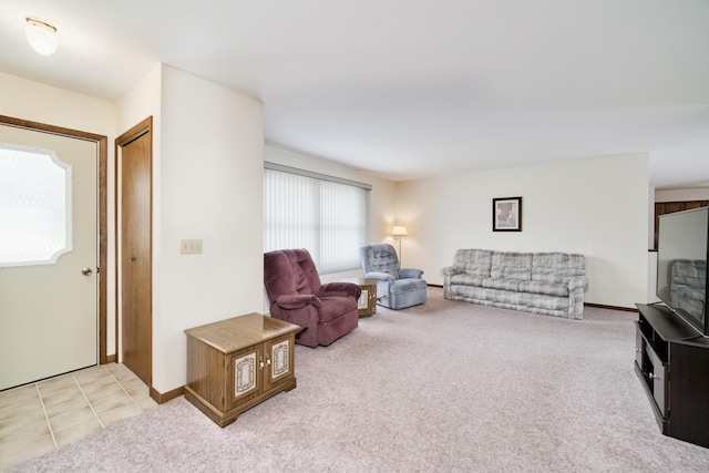 living area featuring baseboards and light colored carpet