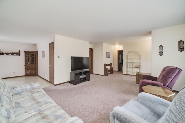living area with baseboards and light colored carpet
