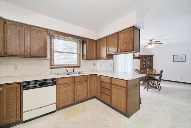kitchen featuring a peninsula, ceiling fan, light countertops, a sink, and dishwasher