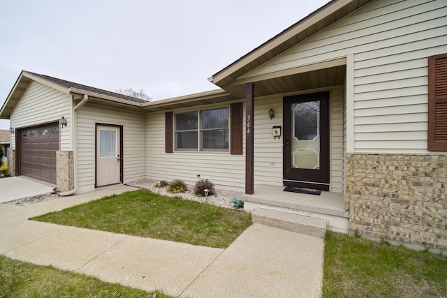 view of exterior entry featuring a garage and concrete driveway