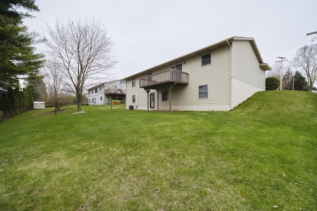 rear view of property featuring a lawn and a wooden deck
