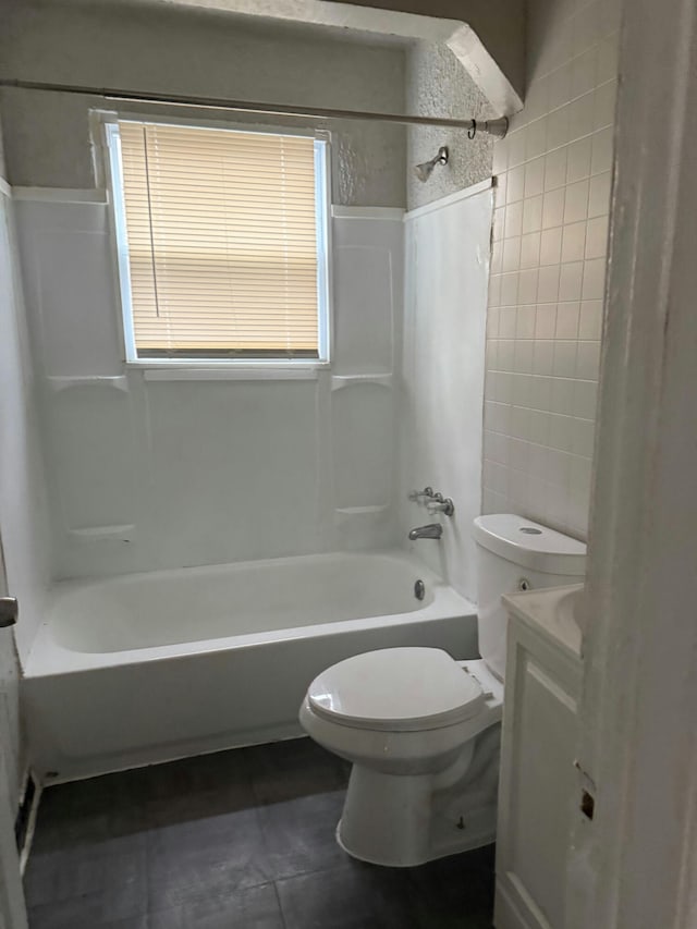 bathroom with tile patterned flooring, a wainscoted wall, vanity, toilet, and tub / shower combination