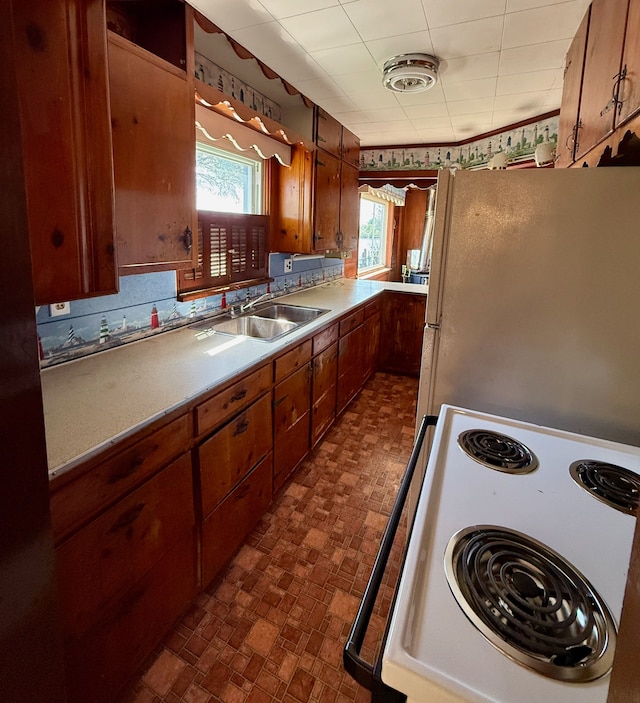 2964 Morin Point St, Erie, MI 48133 - kitchen featuring a sink, freestanding refrigerator, range with electric stovetop, and brown cabinets