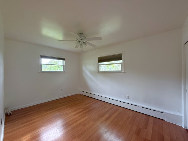 5781 Wright Dr, Troy, MI 48098 - spare room featuring a baseboard heating unit, light wood-style flooring, ceiling fan, and baseboards