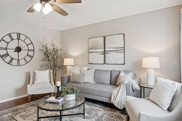 living room featuring baseboards, a ceiling fan, and wood finished floors