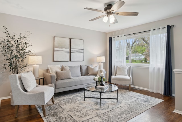 living room with baseboards, visible vents, ceiling fan, and wood finished floors