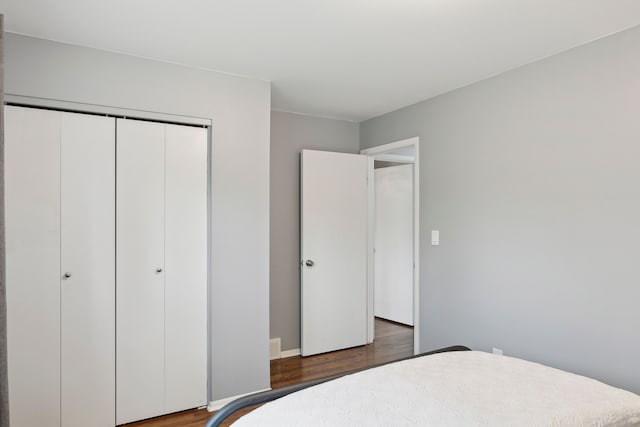 bedroom with baseboards, a closet, and wood finished floors