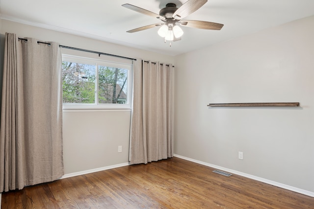 unfurnished room featuring ceiling fan, baseboards, visible vents, and wood finished floors