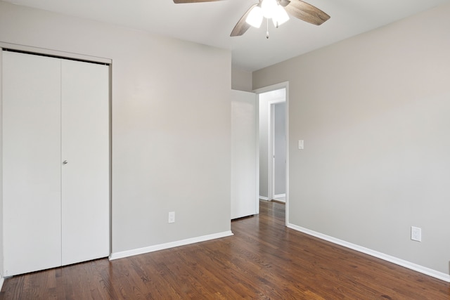 unfurnished bedroom featuring baseboards, a closet, a ceiling fan, and wood finished floors