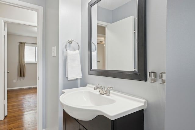 bathroom featuring baseboards, wood finished floors, vanity, and visible vents