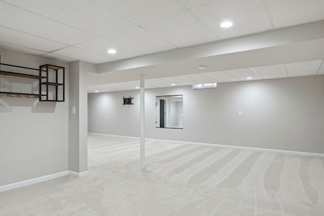 finished basement featuring light colored carpet, recessed lighting, baseboards, and a paneled ceiling