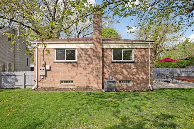 view of property exterior with central AC, a patio area, fence, and a lawn