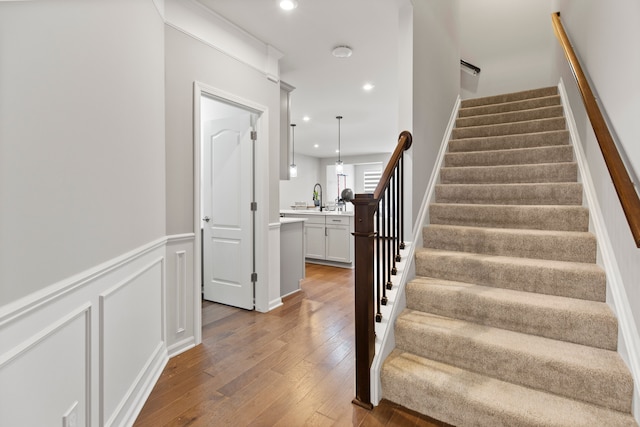 4867 Glenora Dr, Lake Orion, MI 48359 - staircase with hardwood / wood-style flooring, recessed lighting, and a wainscoted wall