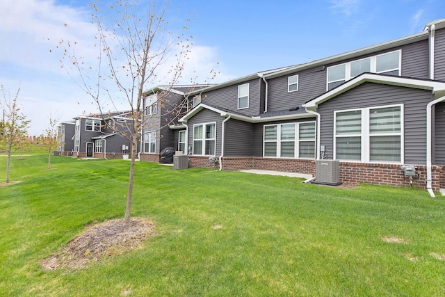 4867 Glenora Dr, Lake Orion, MI 48359 - back of property with central AC, brick siding, and a lawn