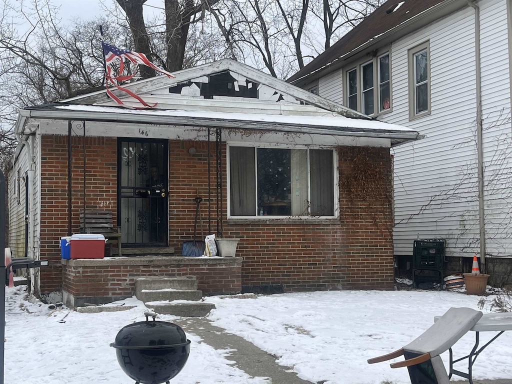 view of front of house featuring a porch and brick siding