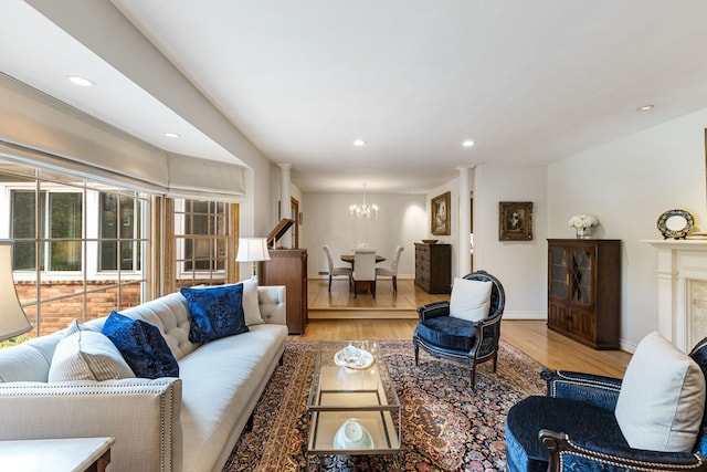 living room with a chandelier, wood finished floors, baseboards, and recessed lighting