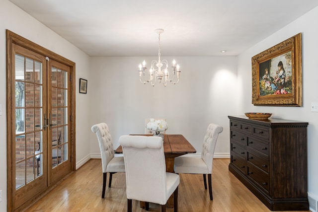 dining room with a chandelier, baseboards, french doors, and light wood-style floors