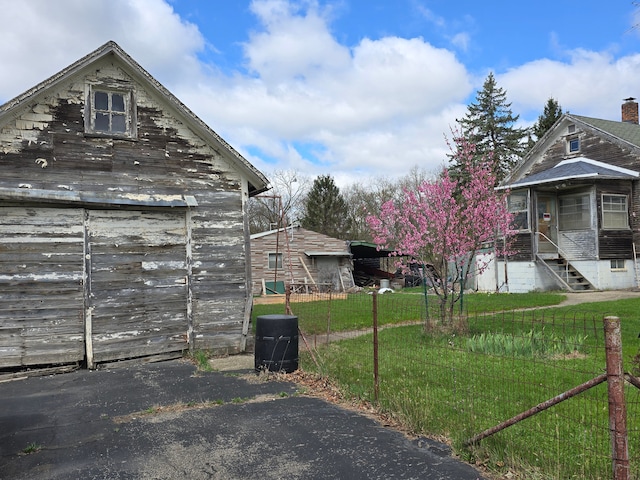 1315 Mitchell St, Jackson, MI 49203 - view of property exterior with fence, a barn, an outdoor structure, and a lawn