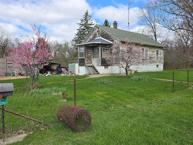 1315 Mitchell St, Jackson, MI 49203 - view of front of property with a shingled roof, a chimney, and a front lawn
