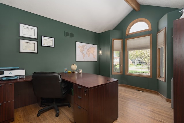 office featuring visible vents, light wood finished floors, baseboards, and vaulted ceiling with beams