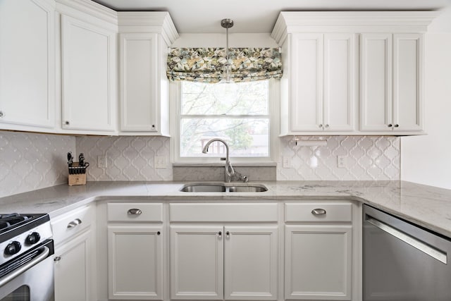 kitchen featuring stainless steel appliances, light stone countertops, white cabinetry, and a sink