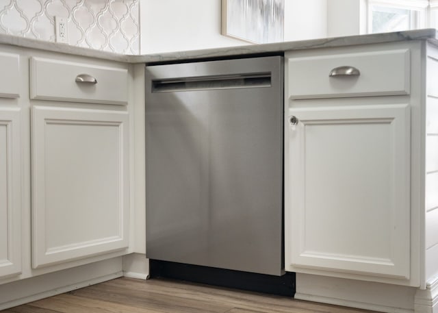 room details featuring light countertops, white cabinetry, wood finished floors, and dishwasher