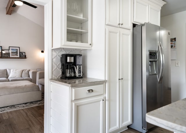 kitchen featuring stainless steel refrigerator with ice dispenser, wood finished floors, open floor plan, glass insert cabinets, and white cabinetry