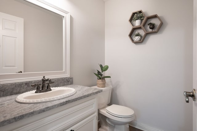 half bath featuring toilet and vanity