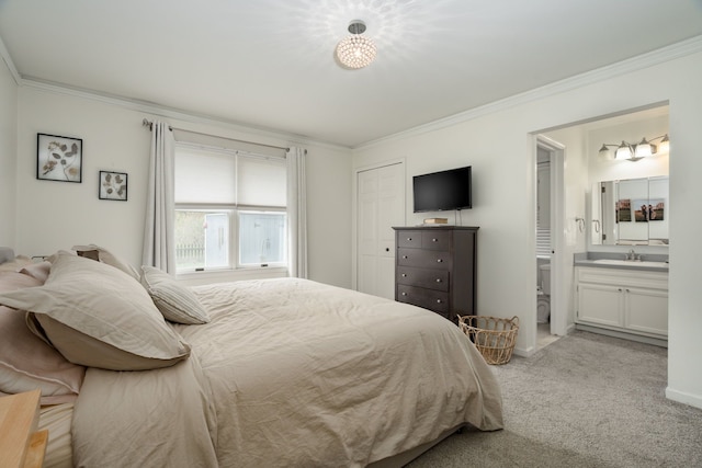 bedroom with connected bathroom, light colored carpet, a sink, ornamental molding, and a closet