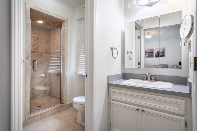 full bathroom featuring vanity, tile patterned floors, a stall shower, and toilet