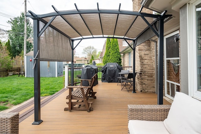 wooden terrace featuring a yard, grilling area, an outbuilding, and a shed