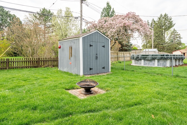 view of shed featuring a fire pit and a fenced backyard